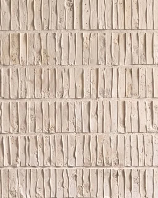 A close view of pale textured brickwork shared by Deboss Collective.
